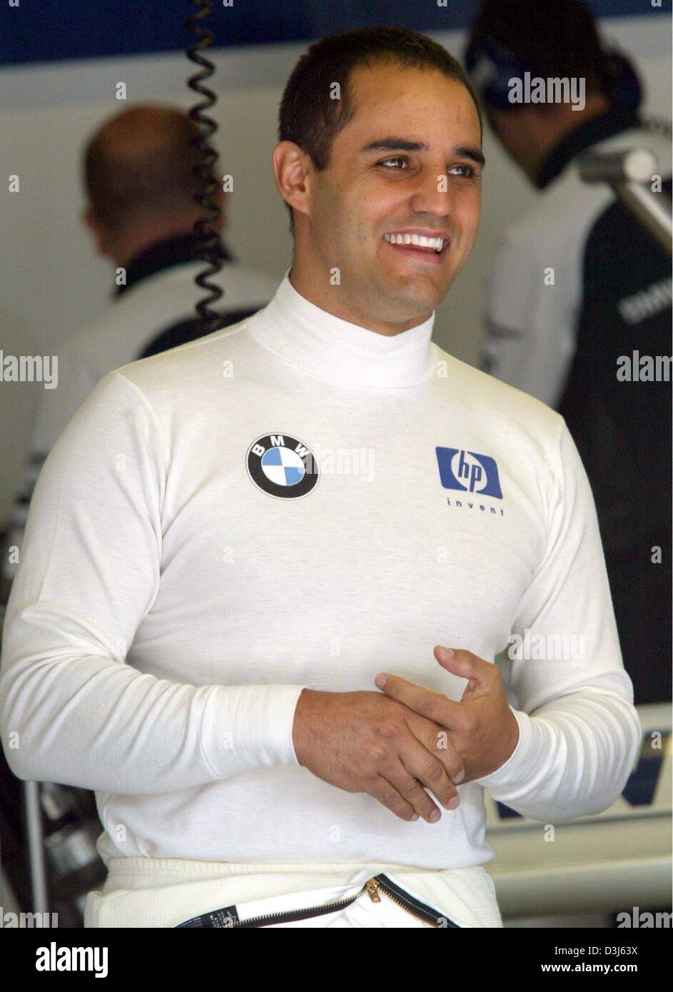 (dpa) - Colombian formula one pilot  Juan Pablo Montoya of BMW-Williams smiles as he stands in the pit during the free training at the Nuerburgring race track in Germany, Friday 28 May 2004. The European Grand Prix takes place at the Nuerburgring on 30 May 2004. Stock Photo