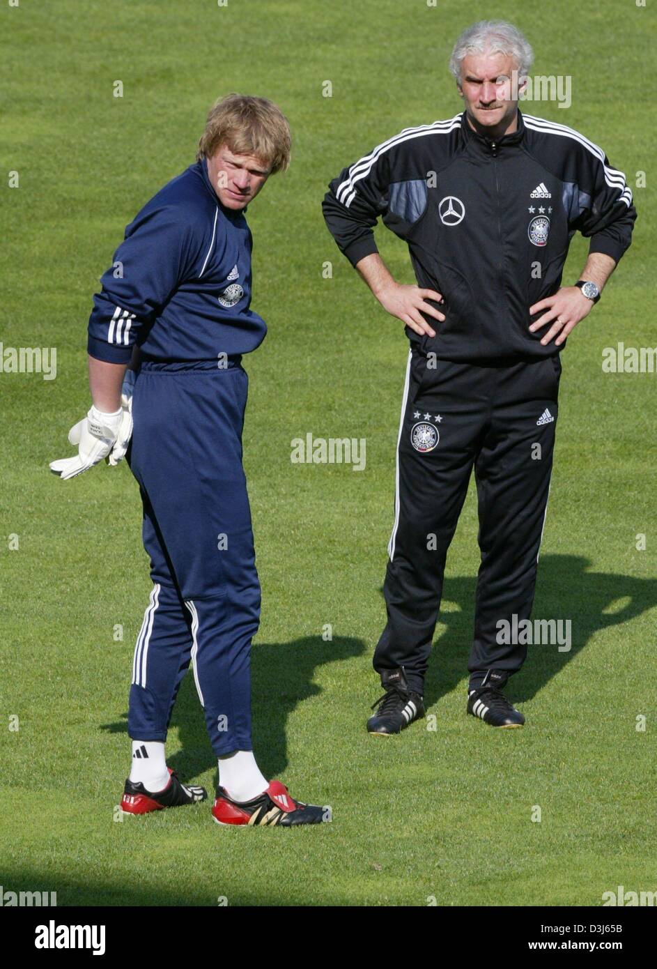 (dpa) - Rudi Voeller (R), head coach of the German national soccer team, and goalkeeper Oliver Kahn stand on the pitch during a training session in Freiburg, Germany, 26 May 2004. As part of their preparation for the upcoming European World Cup in Portugal the German team will meet the national soccer team of Malta in a charity game on Thursday 27 May 2004. Stock Photo