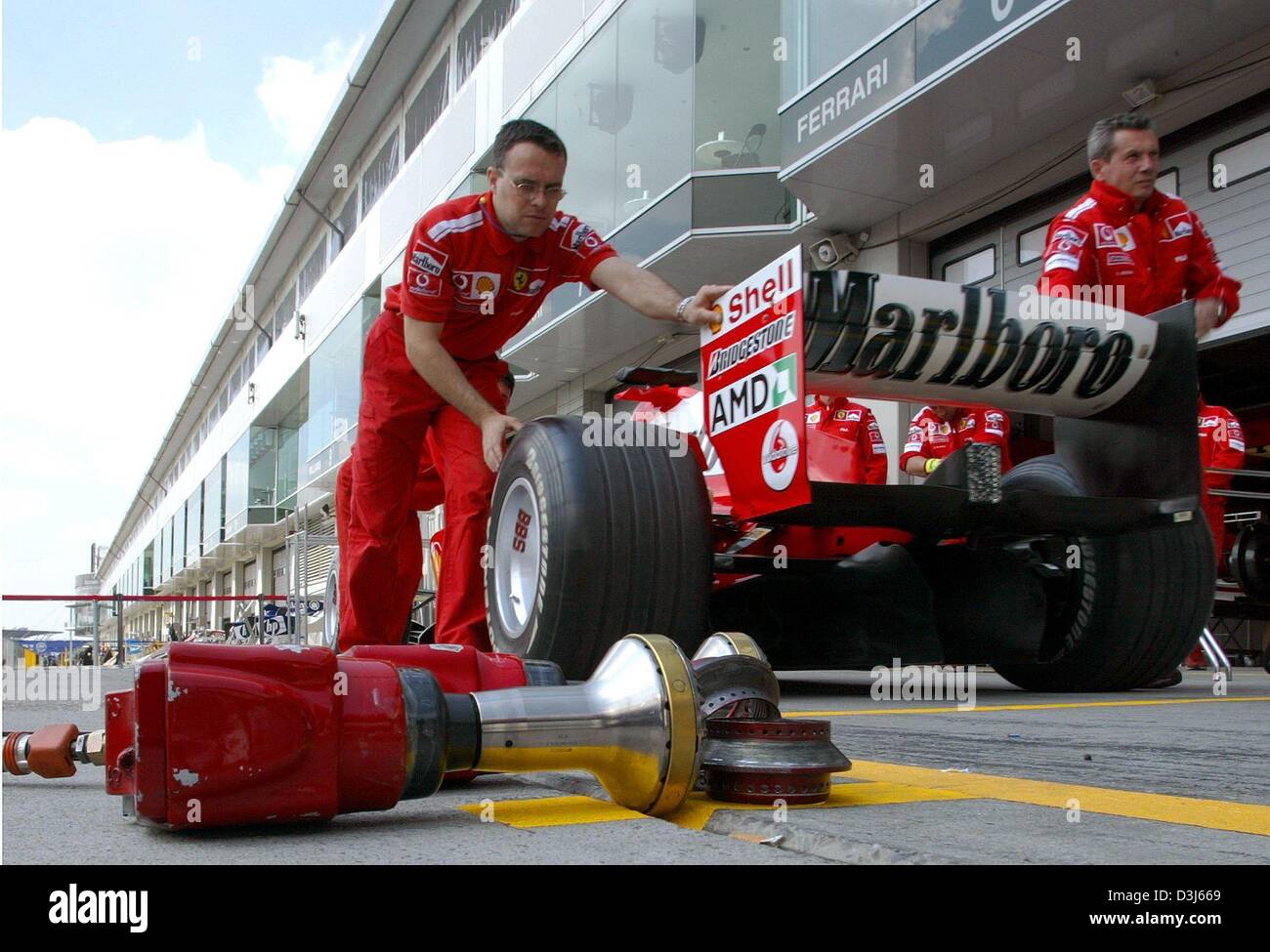 (dpa) Ferrari mechanics push the car of German Formula 1 champ