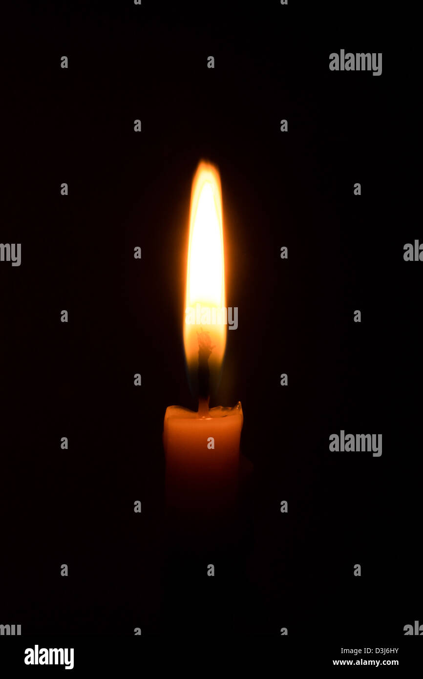 light burning candle in darkness background Stock Photo