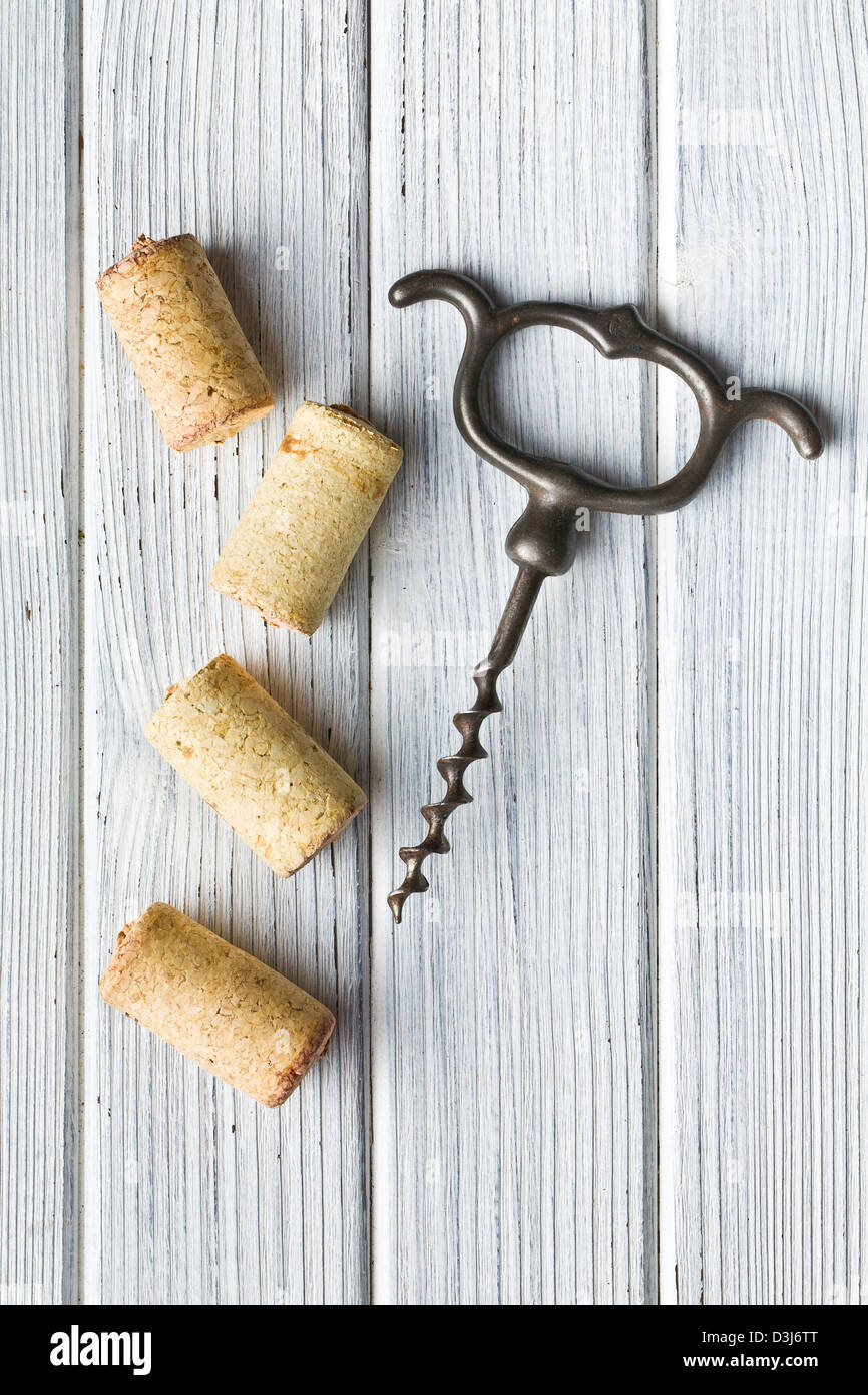 vintage corkscrew and wine corks on wooden table Stock Photo