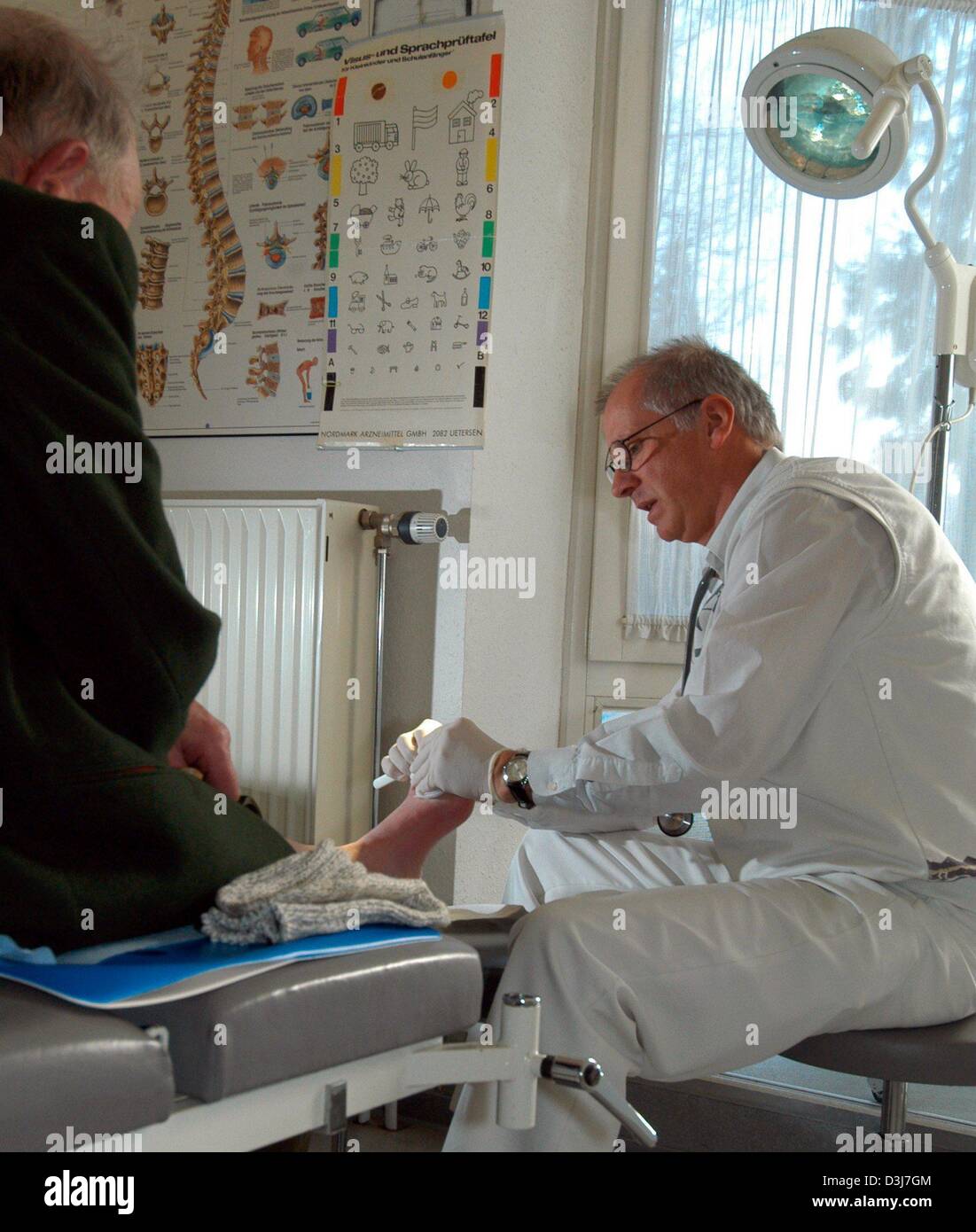 (dpa) - Physician Rainer Graeter treats a patient's foot injury in Essingen, Germany, 16 February 2004. Graeter is a country doctor in the rural German 'Schwaebische Alb' region. Next to his practice he also visits his patients at their houses. Stock Photo