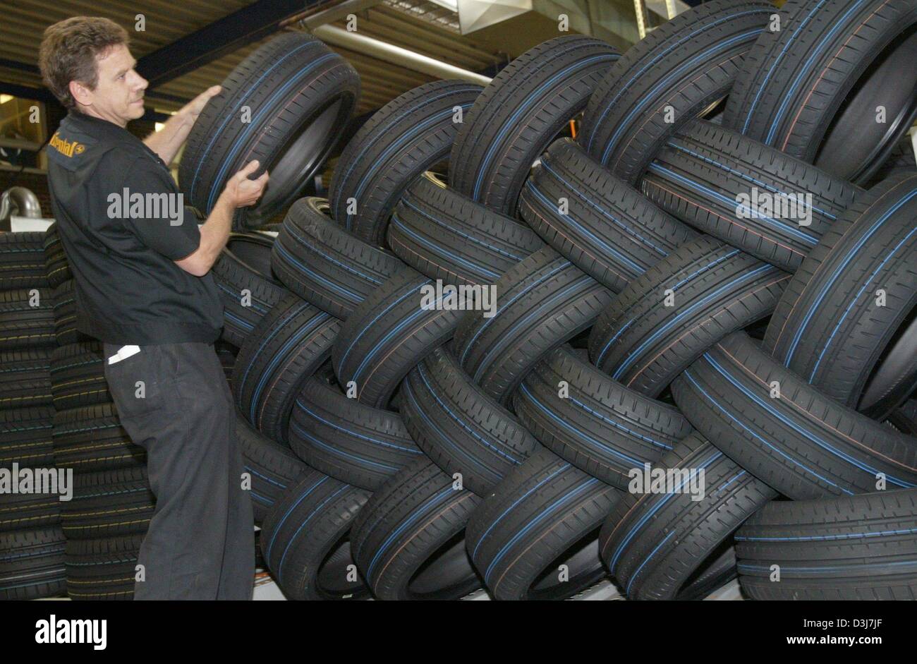 (dpa) A worker puts new tires on a stack at the plant of German tire