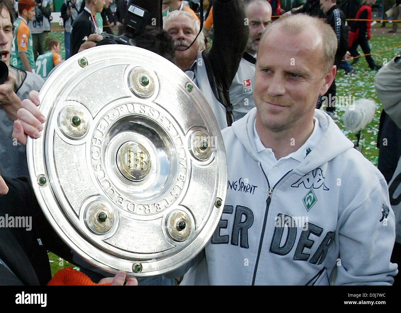 (dpa) - Bremen's soccer coach Thomas Schaaf smiles as he poses with the German Bundesliga trophy in his hand after the Bundesliga soccer game opposing SV Werder Bremen and Bayer 04 Leverkusen in Bremen, Germany, 15 May 2004. Bremen had already secured the 2003/2004 Bundesliga champion's title in the soccer game against FC Bayern Munich two days before the end of the Bundesliga seas Stock Photo