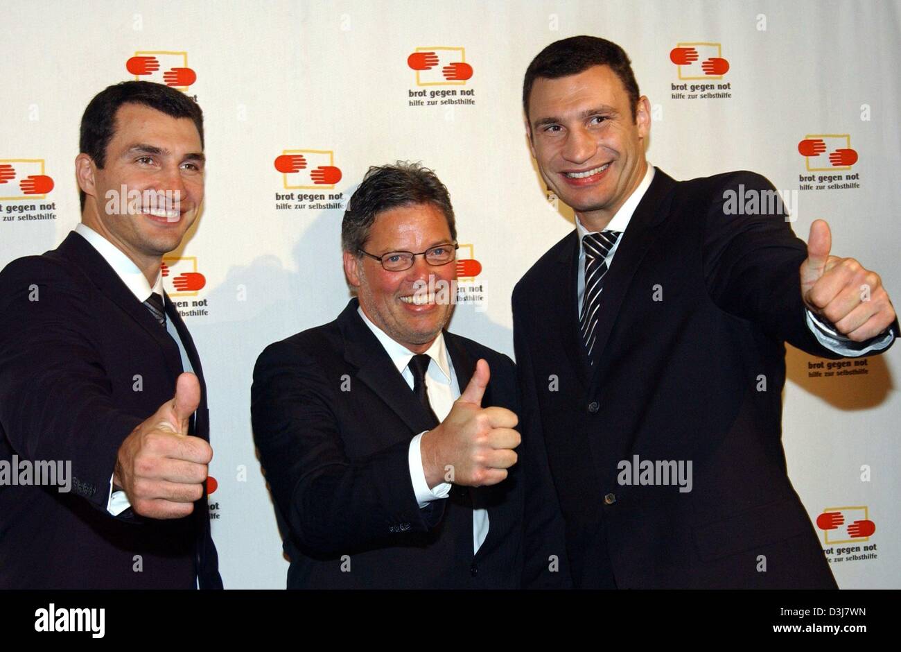 (dpa) - German bakery entrepreneur Heiner Kamps (C) is flanked by the two boxing pros, Wladimir (L) and Vitali Klitschko, during the charity gala of the 'Brot gegen Not' (bread against poverty) foundation in Duesseldorf, Germany, 14 May 2004. 'Brot gegen Not' was founded by Kamps in 2000 and funds teenagers in need in Third World countries. Stock Photo