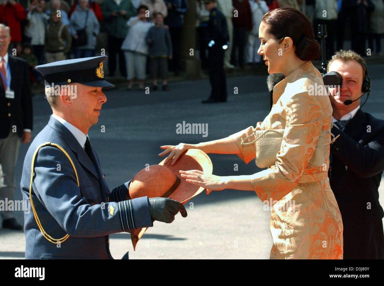 (dpa) - Mary Donaldson, the Australian fiancee of Crown Prince Frederik of Denmark, is given back her hat from a policeman. The hat had been blown off her head during a visit of the Parliament in Copenhagen, Denmark, 13 May 2004. Donaldson will wed Crown Prince Frederik at the Cathedral in Copenhagen on Friday 14 May 2004. Stock Photo