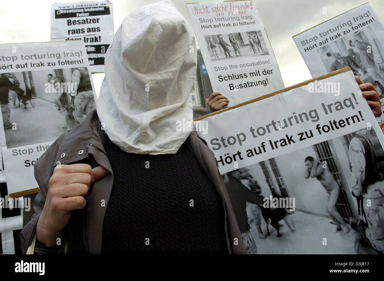 (dpa) - A woman opposing the USA's policy in Iraq demonstrates with a bag over her head and a sign in her hand saying 'Stop torturing Iraq!' in Berlin, Germany, 13 May 2004. Because of accusations of the mistreatment of Iraqi prisoners by British and US-American soldiers in Iraq, activists gathered in front of the USA's embassy in Berlin to voice their protests. Stock Photo