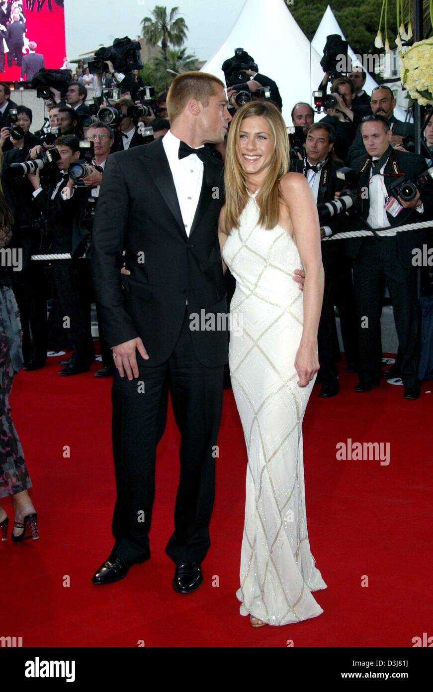 (dpa) - Hollywood star Brad Pitt whispers into the ear of his wife Jennifer Aniston upon their arrival at the presentation of Pitt's new movie 'Troy' at the 57th Film Festival in Cannes, France, 13 May 2004. In the movie Pitt stars as Greek hero Achilles. Stock Photo