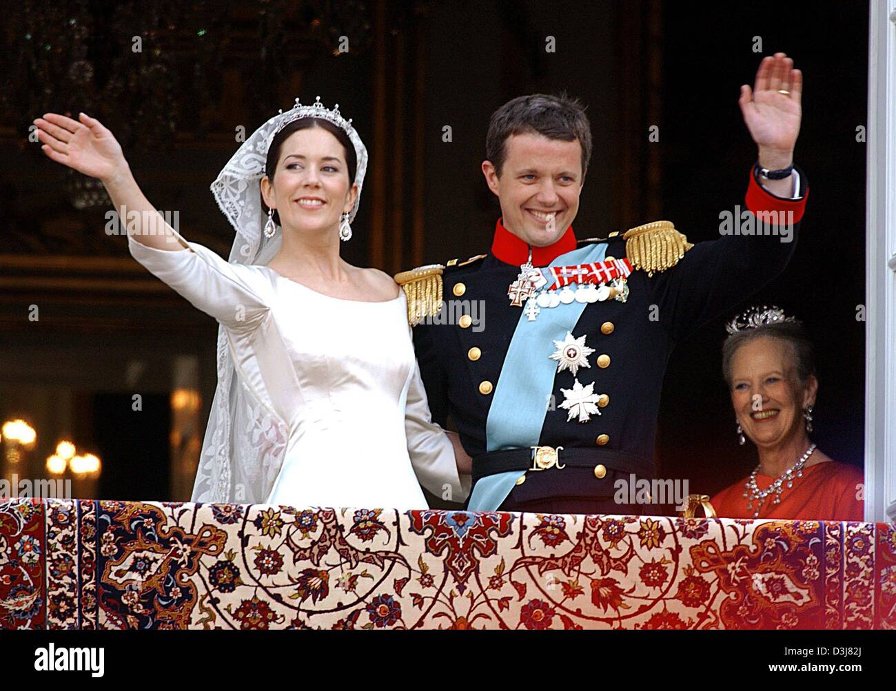 (dpa) - Danish crown prince Frederik (C) and his wife Mary Donaldson smile and wave their hands while Danish queen Margrethe (R) looks on as they stand on the balcony of Chateau Amalienborg after their wedding in Copenhagen, Denmark, Friday, 14 May 2004. The church wedding of crown prince Frederik and Mary Donaldson from Australia took place today. Members of all European royal dyn Stock Photo