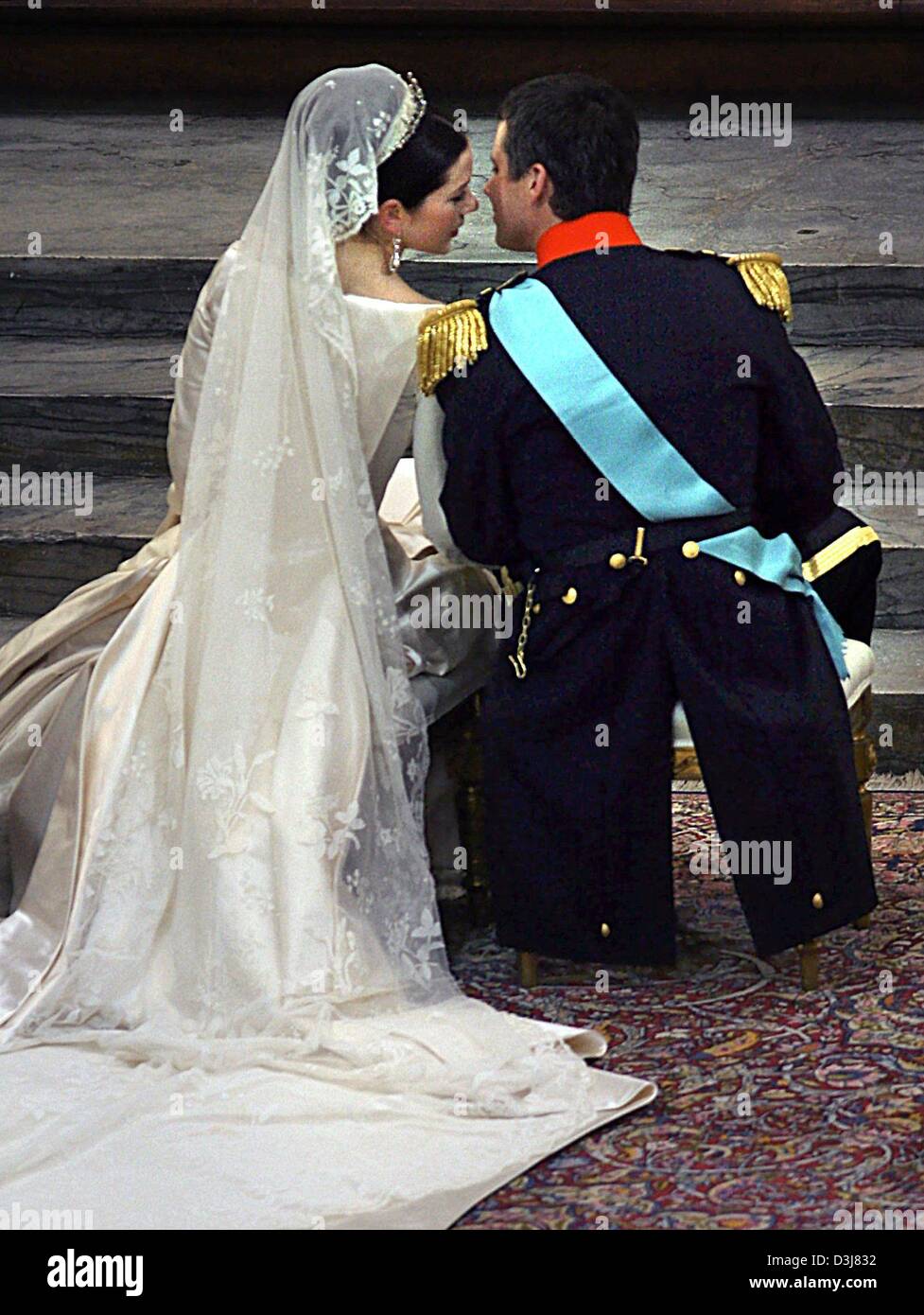 (dpa) - Danish crown prince Frederik (R) turns to his wife Mary Donaldson as both sit in front of the altar during their wedding ceremony at the cathedrale in Copenhagen, Denmark, Friday, 14 May 2004. Members of all European royal dynasties were among the 800 invited guests who attended the wedding. The thirtyfive-year-old heir to the Danish thrown met his thirtytwo-year-old bride  Stock Photo
