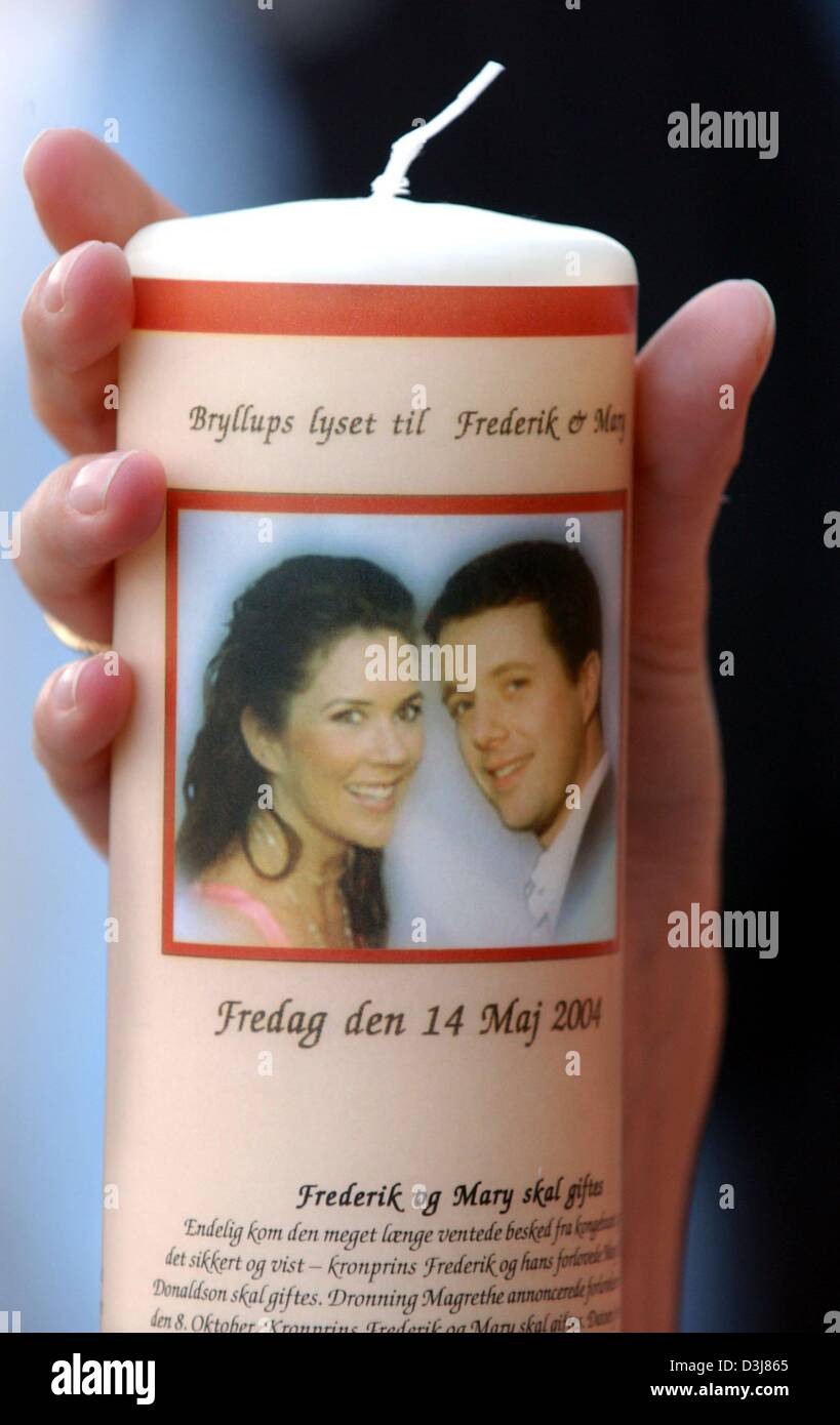 (dpa) - A hand presents a candle whic displays an image of the bridal couple crown prince Frederik of Denmark and Mary Donaldson in a souvenir shop in Copenhagen, Denmark, 11 May 2004. The preparations for the royal wedding, on Friday, 14 May 2004, are underway. Stock Photo