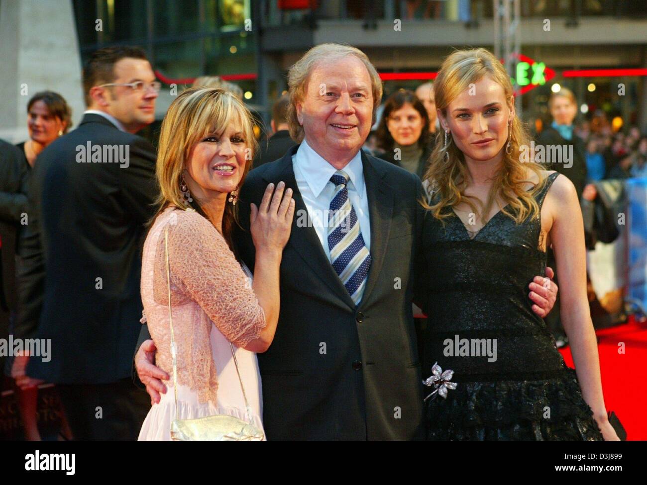 (dpa) - German film director Wolfgang Petersen (C) poses together with his wife Maria (L) and German actress Diane Kruger on their arrival to the premiere of Petersen's new film 'Troy' in Berlin, 9 May 2004. The film is going to be released in Germany on 13 May 2004. Stock Photo