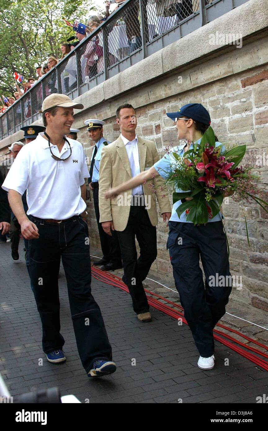 (dpa) - Crown prince Frederik of Denmark (L) and his fiancee Mary Donaldson, who carries a bunch of flowers in her hands, leave the harbour of Copenhagen, Denmark, 9 May 2004. Both were competing with each other in a sailing regatta which was eventually won by Mary. Stock Photo