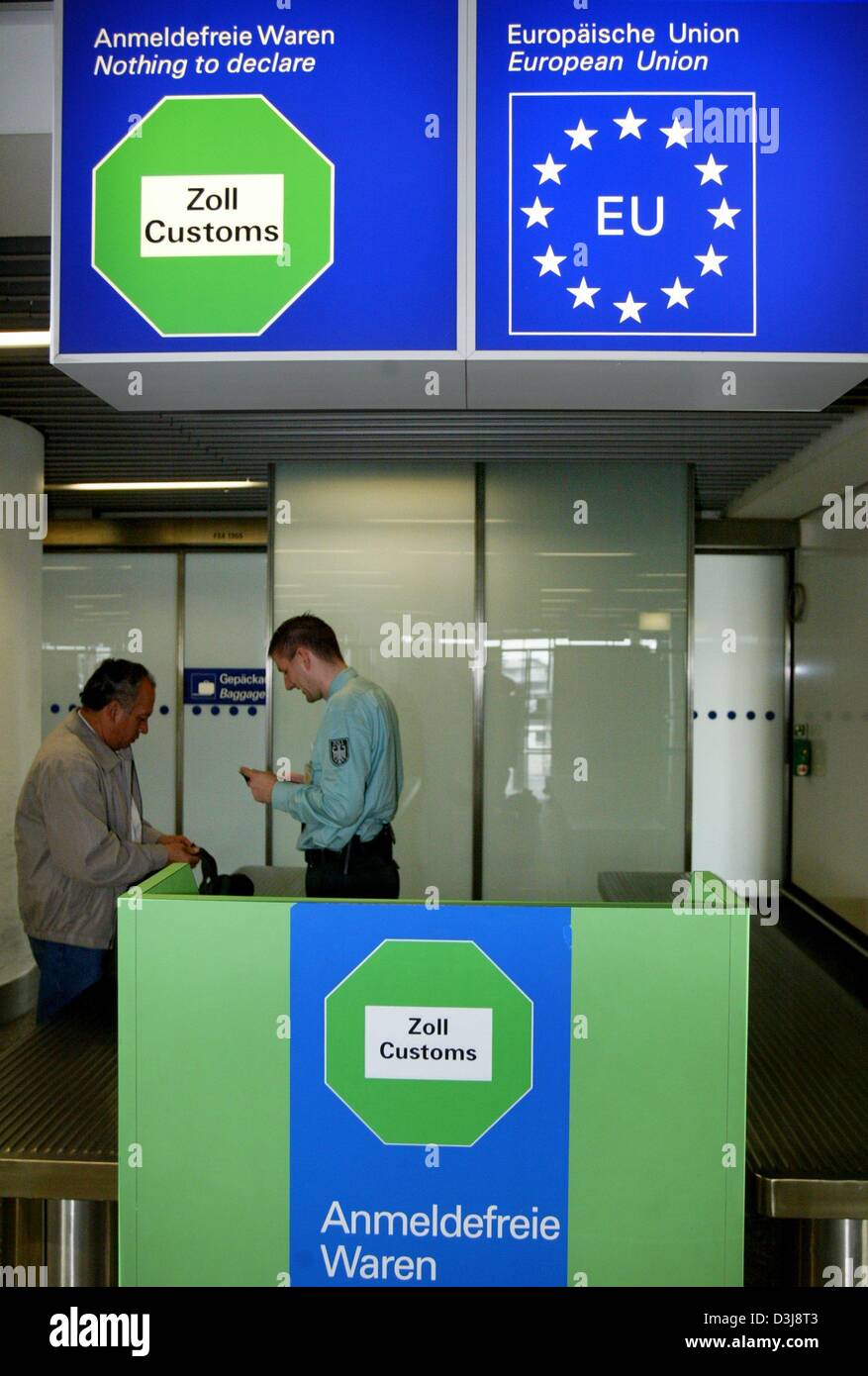 (dpa) - A customs officer checks the documents and the luggage of a passenger at the airport in Frankfurt, Germany, 20 April 2004. In the past several customs checkpoints at Germany's largest airport had been unoccupied, but officials claimed that supervision had been sufficient due to random checks that were regularly performed. Stock Photo