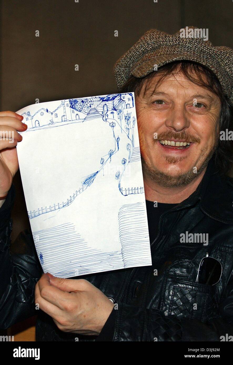 (dpa) - Italian musician, blues singer and song writer Zucchero smiles as he presents his drawing titled 'my farm in Italy' in a hotel in Hamburg, Germany, 22 April 2004. 48-year-old musician promoted his new album which contains a collection of duets with international singers. The album, which took him 15 years to produce, will be officially introduced during a UN charity concert Stock Photo