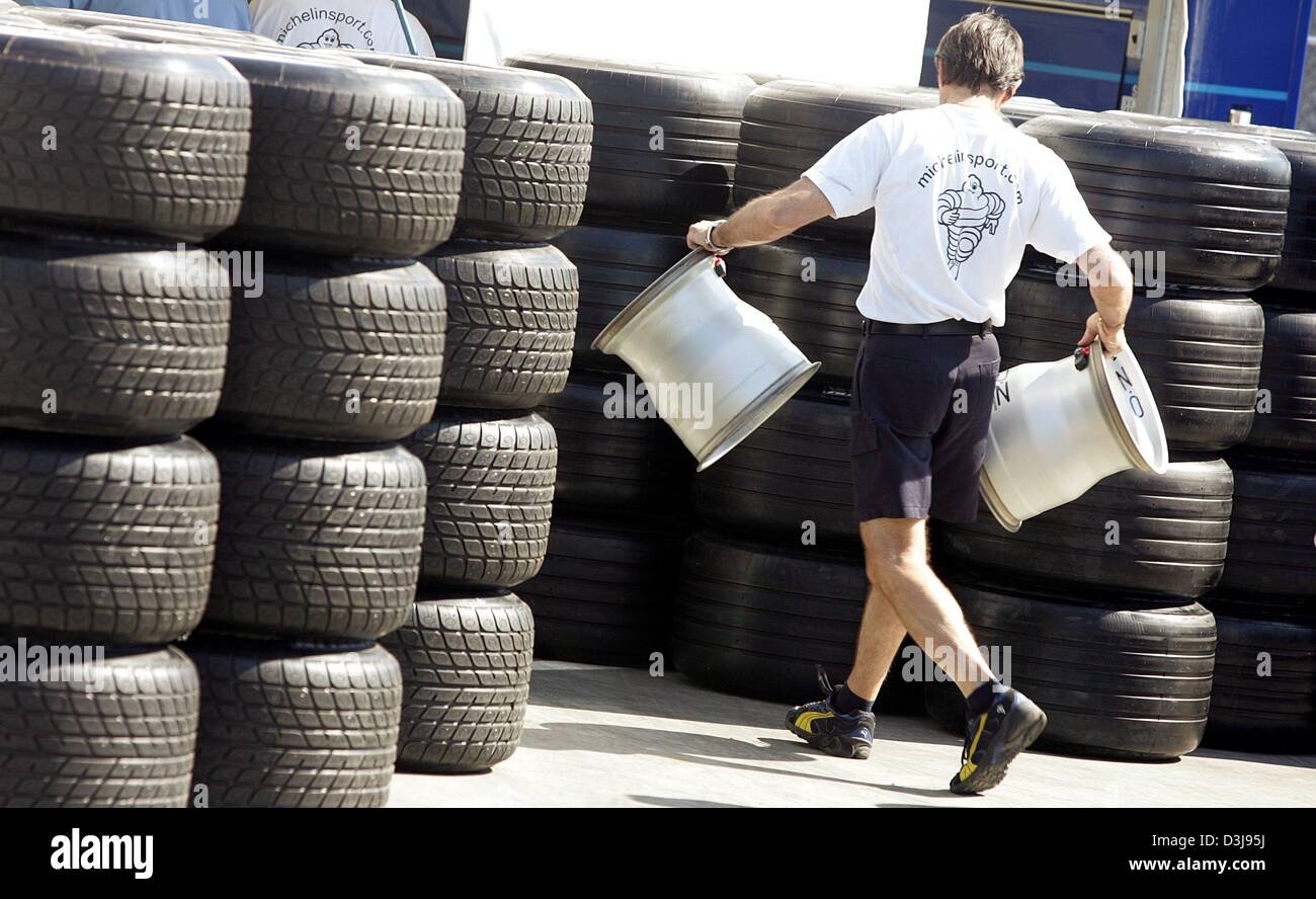 dpa) - An employee of tire manufacturer Michelin carries a pair of rims in  front of stacks of tires at the race track 'Enzo e Dino Ferrari' in Imola,  Italy, 22 April