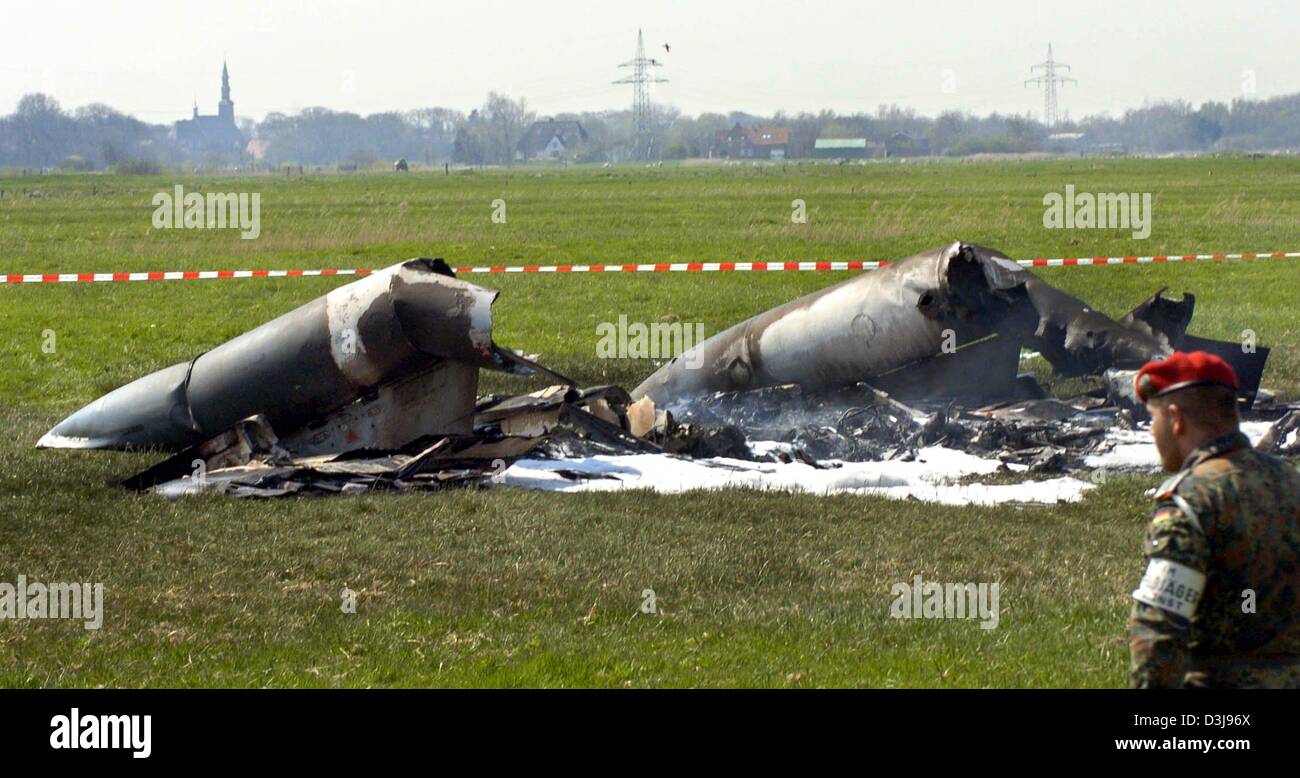 (dpa) - A soldier guards the wreckage of two German Tornado fighter jets which collided in mid-air near the town of Garding, northern Germany, on Wednesday, 21 April 2004. Two crew members were killed in the crash but two others were able to parachute to safety, police said. Stock Photo