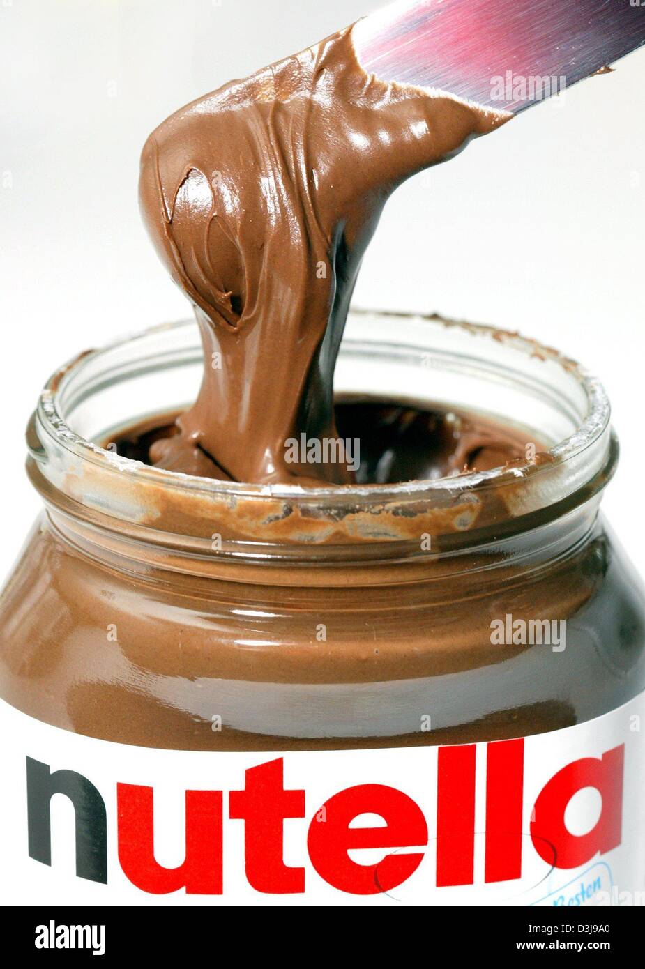 (dpa) A knife dips into a glass of Nutella chocolate spread, in