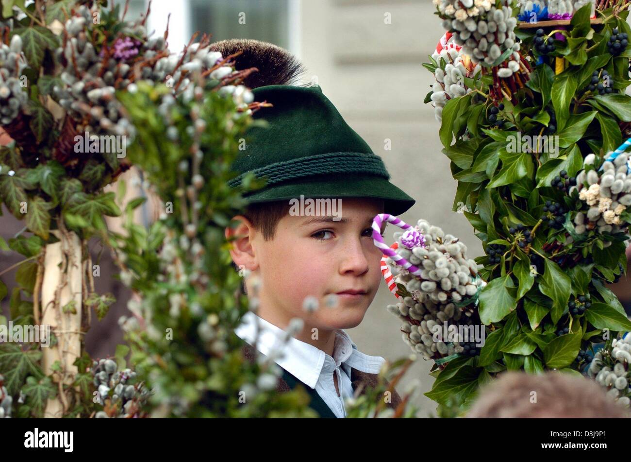 (dpa) - A boy looks past palm branches which are bound with ivy and willow catkins during a traditional palm procession in Bad Toelz, Germany, 4 April 2004. The children in the procession usually have their first communion right after Easter. The procession reminds of Jesus entering Jerusalem which also marks the start of the Holy Week before Easter. Stock Photo