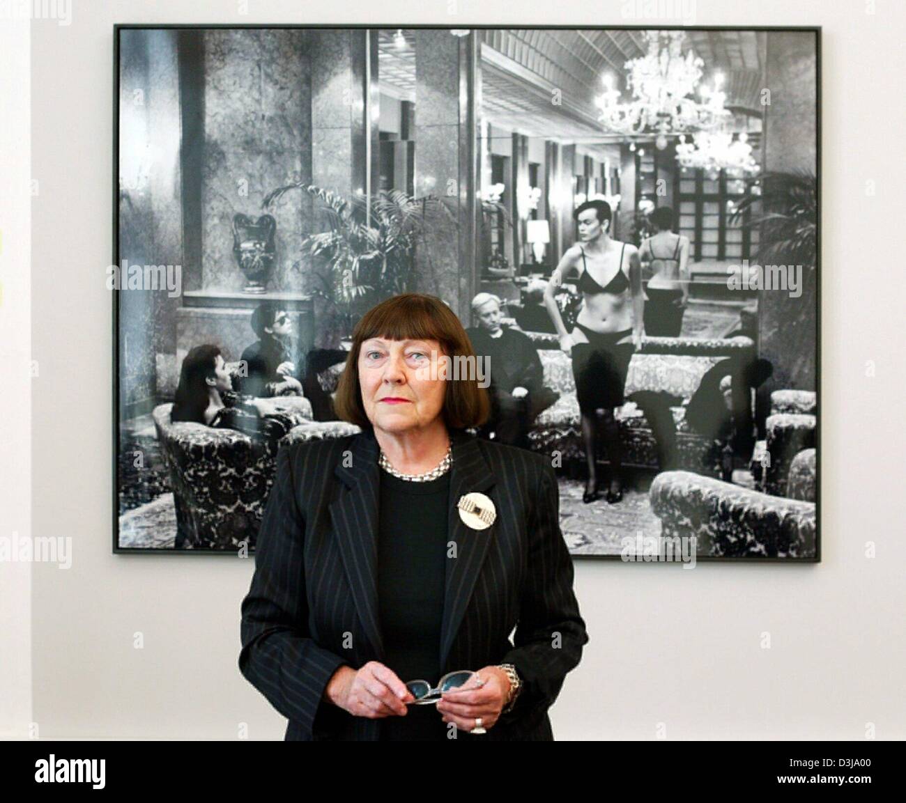 (dpa) - (dpa) - June Newton, wife of recently departed Berlin-born US star photographer Helmut Newton poses in front of one of her husband's pictures at the former art library in Berlin, 2 April 2004. The exhibition rooms of the art library will accommodate the photographic works of Newton which he had given to the city of Berlin as a permanent loan. Newton, who died in a traffic a Stock Photo
