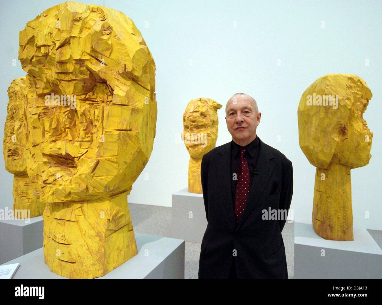 (dpa) - German artist Georg Baselitz stands between his wooden sculptures 'Dresdener Frauen' (women of Dresden) at the Bundeskunsthalle (federal art hall) in Bonn, Germany, 31 March 2004. The retrospective which will be held at the art hall from 2 April until 8 August 2004, titled 'Pictures That Turn Your Head', is a comprehensive overview of approximately 130 works of art from all Stock Photo