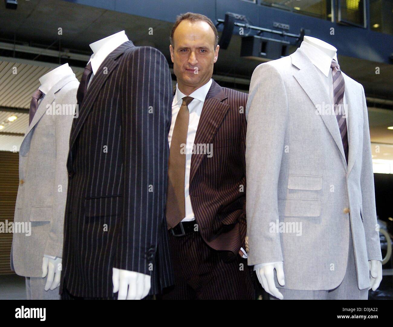 (dpa) - Bruno Saelzer, CEO and Chairman of German fashion giant Hugo Boss, stands between current suit models during a balance press conference at the company's headquarters in Metzingen, Germany, 1 April 2004. The company is set to slightly raise profits this year. Stock Photo