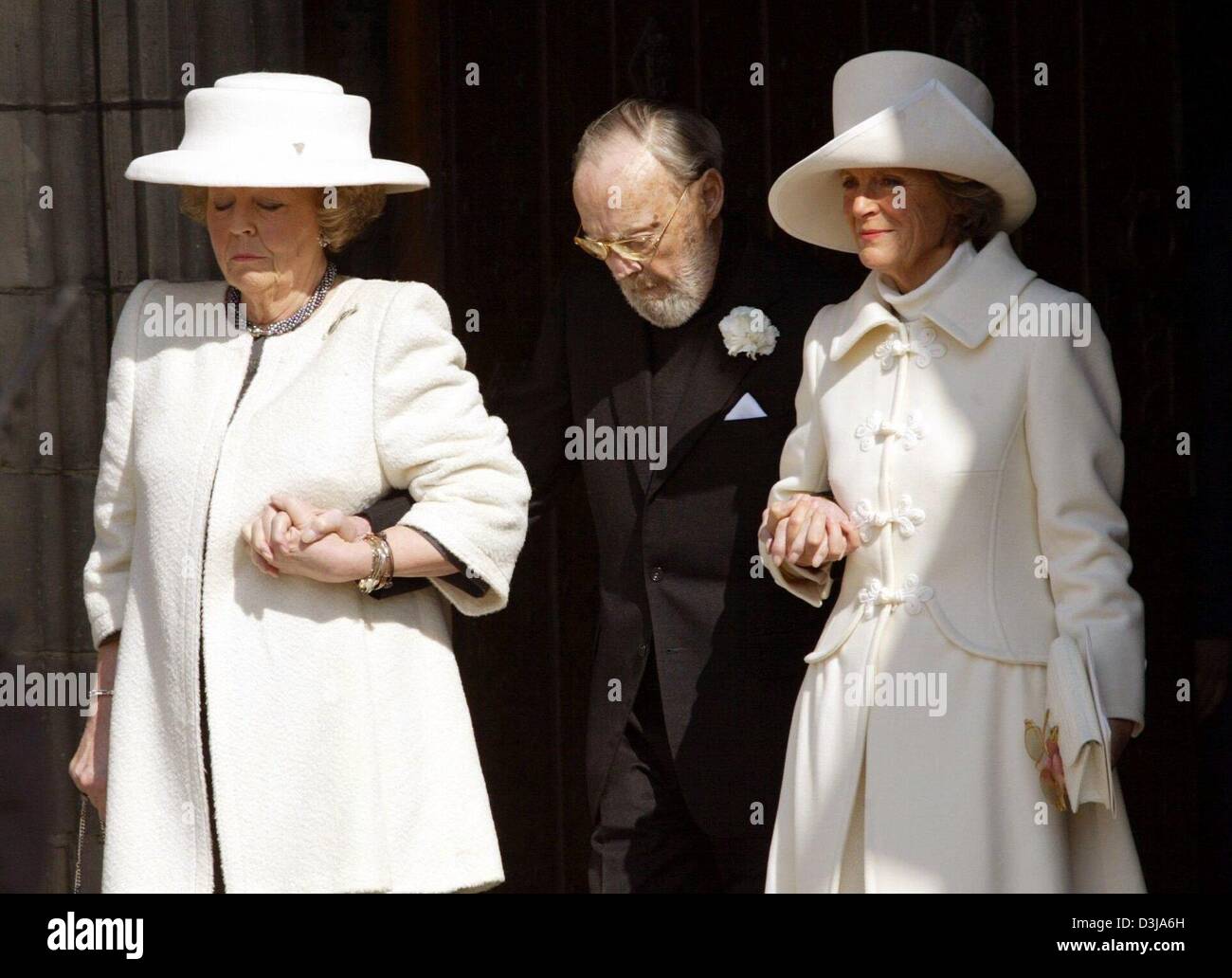 (dpa) -  Queen Beatrix (L) of the Netherlands and her sister Princess Irene (R) support Prince Bernhard as they attend the funeral of former Dutch Queen Juliana at the Nieuwe Kerk (New Church) in Delft, Netherlands, 30 March 2004. The former queen died on 20 March 2004 at the age of 94 and was buried in the family crypt in Delft. Crowds of people arrived to witness the event. Stock Photo