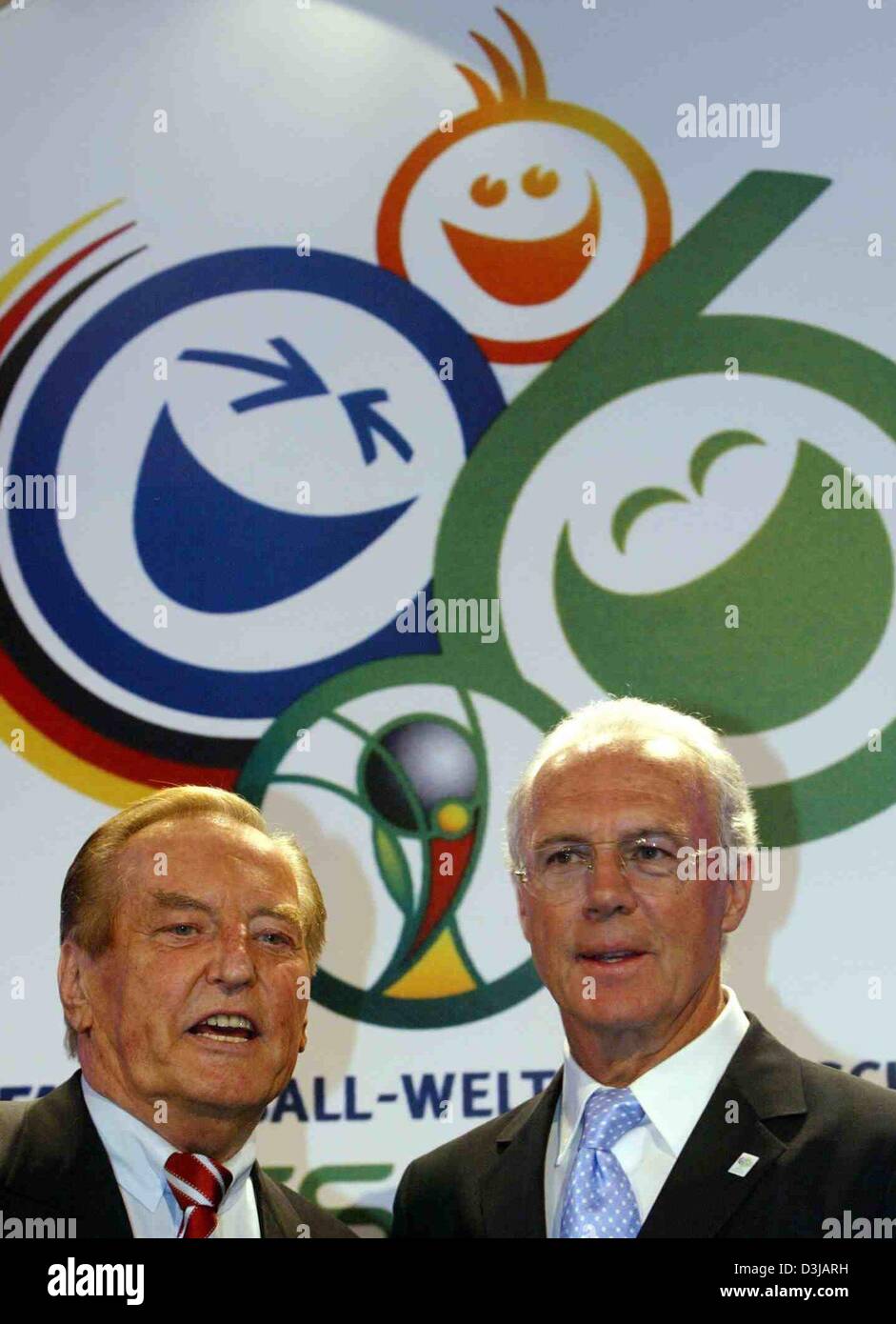 (dpa) - Gerhard Mayer-Vorfelder (L), President of the German Soccer Federation (DFB) and Franz Beckenbauer, President of the organising committee of the FIFA World Cup 2006, stand next to each other in front of the world cup logo and smile during a reception at the town hall in Dortmund, Germany, 18 March 2004. The organising committee invited guests from the world of entertainment Stock Photo