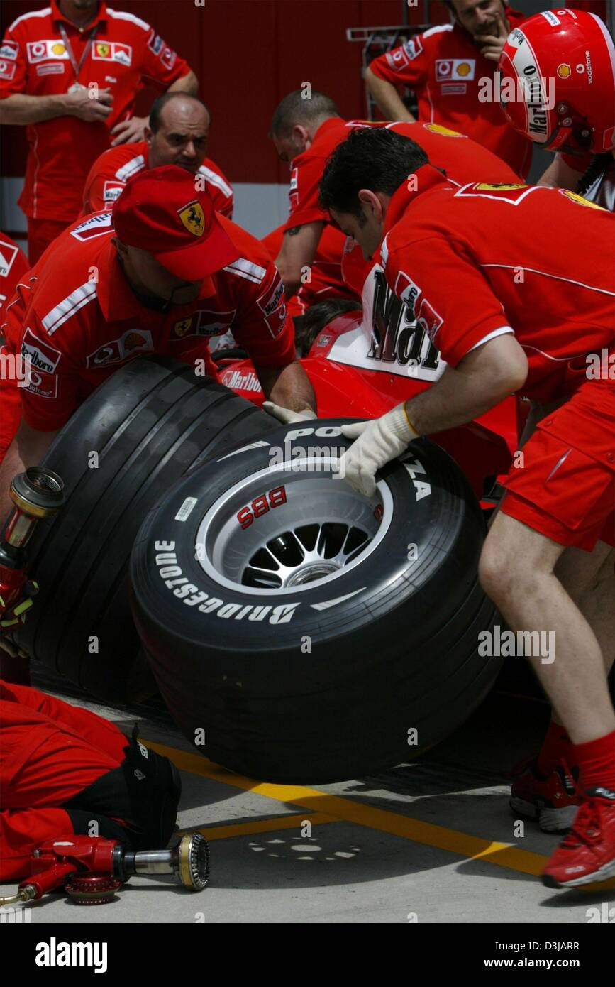 (dpa) Ferrari mechanics train a tire change during the training sessions on Friday, 19 March 2004, at the Selangor racetrack near Kuala Lumpur. On Sunday, 21 March 2004, the Grand Prix of Malaysia will be underway. Stock Photo