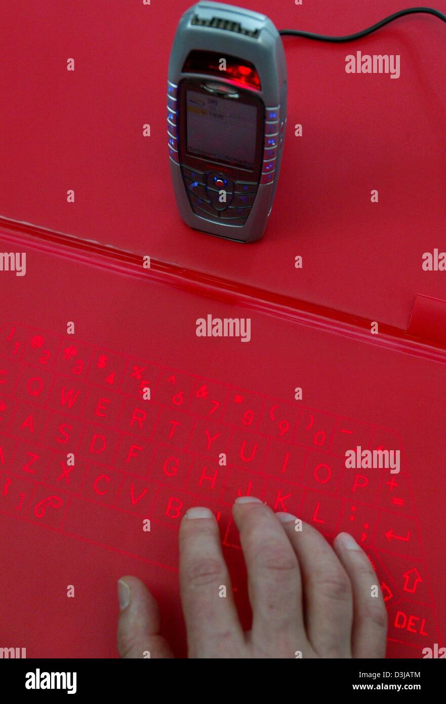 A hand demonstrates the use of a virtual keypad for mobile phones at