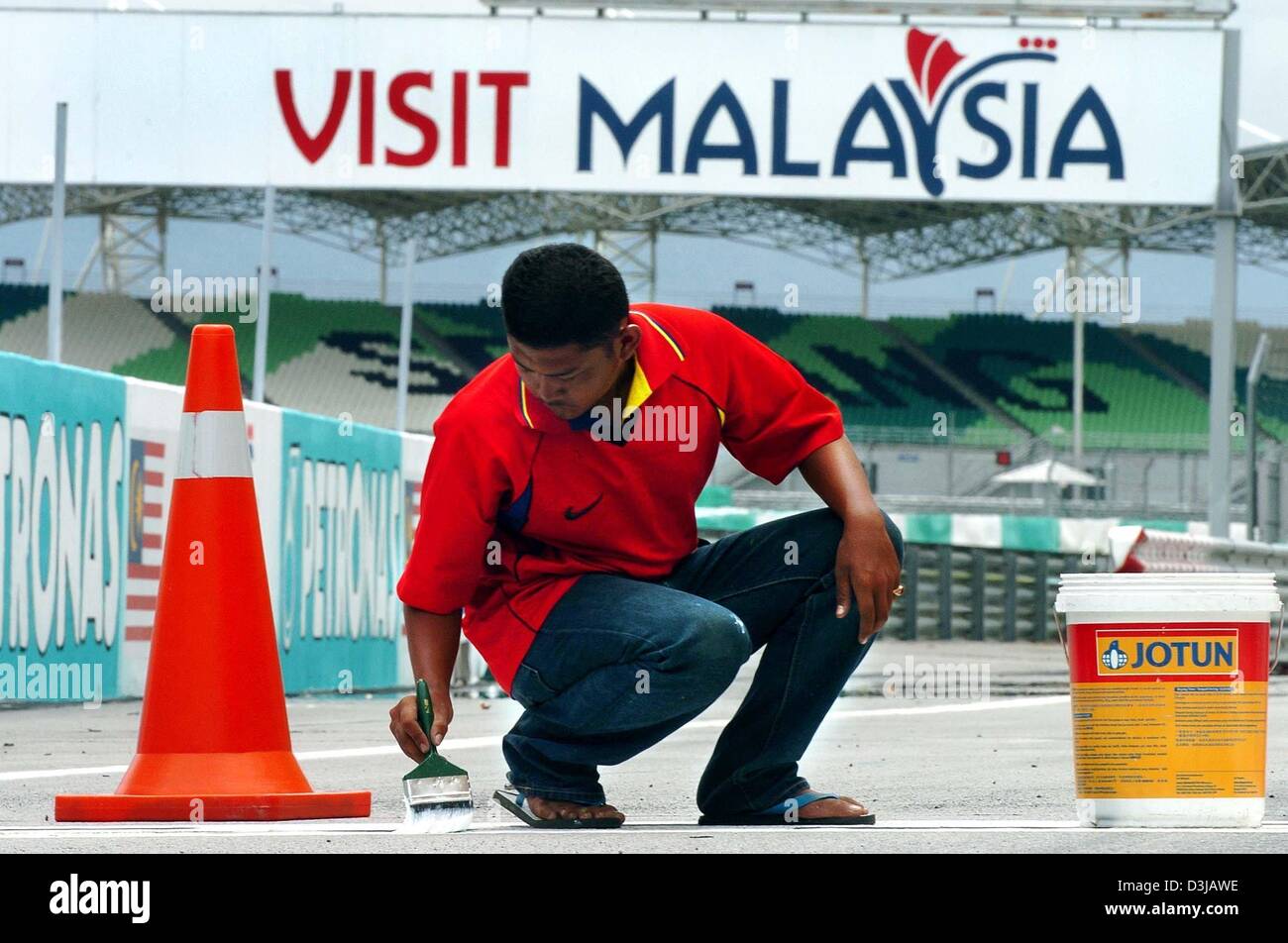 (dpa) A Malaysian navvy paints the last racetrack markers on the Sepang racetrack near Kuala Lumpur on Wednesday, 17 March 2004. On Sunday, 21 March 2004, the Grand Prix of Malaysia will underway. Stock Photo