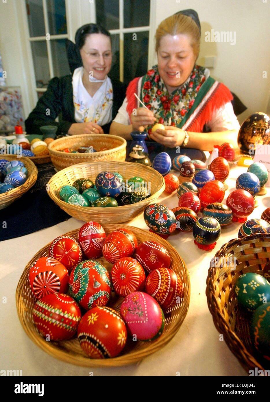 (dpa) - Dorothea Tschoeke (R) paints colourful Sorbian Easter eggs while Elisabeth Sende looks on in Bautzen, Germany, 7 March 2004. 39 folk artists from around Berlin and Lusatia present the different techniques of decorating eggs for the Easter season. Stock Photo