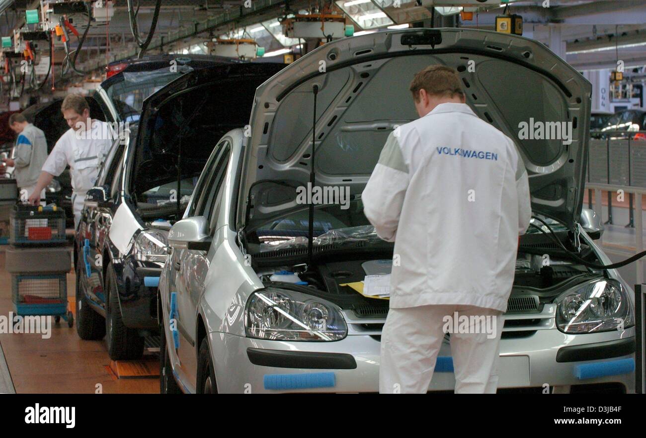 (dpa) - Employees work on the production of VW Golf V at the Volkswagen production plant in Wolfsburg, Germany, 24 February 2004. VW wants to increase sales figures, turnover and business results in the 2004 business year after declining business results in the previous year. VW said operating profits, after adjustments for one-off factors, fell to 1.8 billion euros (2.24 billion d Stock Photo