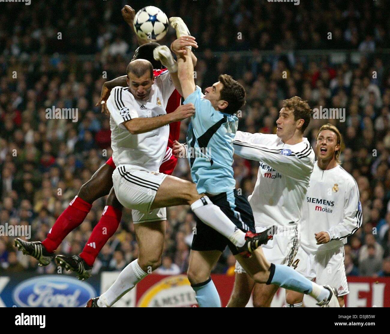 (dpa) Real Madrid players Zinedine Zidane (left), goalie Iker Casillas, Santiago Solari and Guti (right) defend against FC Bayern Munich player Sammy Kofour (covered) during the  Champions League 1/8 final second leg match at the Santiago Bernabeu-Stadium in Madrid on Wednesday, 10 March 2004. Real Madrid won 1:0 and moves on to the next round. Stock Photo