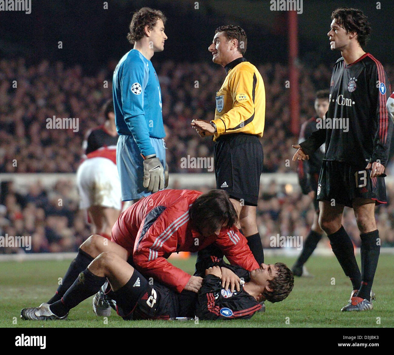 (dpa) - Bayern midfielder Sebastian Deisler (on the pitch) is treated by team physician Hans-Wilhelm Mueller-Wohlfart after a foul while Arsenal goalkeeper Jens Lehmann (L) argues with referee Massimo de Santis (C) and Bayern's Michael Ballack during the UEFA Chmapions League match between English side Arsenal London and Germany's Bayern Munich at Highbury Stadium in London, United Stock Photo