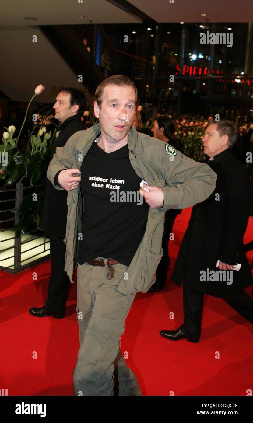 (dpa) - German actor Peter Lohmeyer shows his t-shirt featuring the inscription 'Schoener leben ohne Nazis' (better living without nazis) while walking along the red carpet for the presentation of the competition film 'Sophie Scholl - The Final Days' (Germany) at the 55th Berlinale international film festival in Berlin, Germany, 13 February 2005. A total of 21 films compete for the Stock Photo