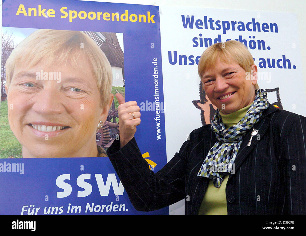 (dpa) - Anke Spoorendonk, top candidate of the voters association of southern Schleswig (SSW), smiles and gives a thumbs up as she poses in front of her election poster in Kiel, Germany, 16 February 2005. Prior to the forthcoming state election of Schleswig-Holstein on 20 February 2005, the SSW remains free of the five percent clause mandatory for political parties. The Federal Con Stock Photo