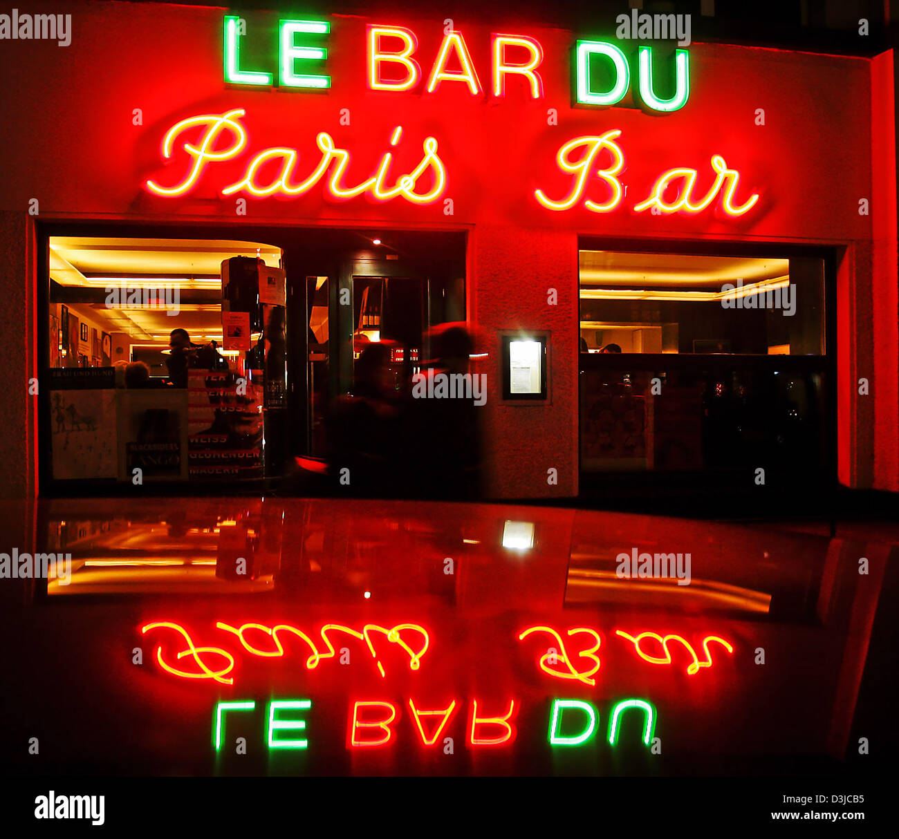 (dpa) - Passers-by walk past the neon lit 'Paris Bar' in Berlin, 11 February 2005. Gastronomy and luxury hotels are hoping for good business during this year's Berlinale Filmfestival.  keywords: Economy-Business-Finance, EBF, Gastronomy, bar, neon light, GERMANY:DEU, night scene Stock Photo