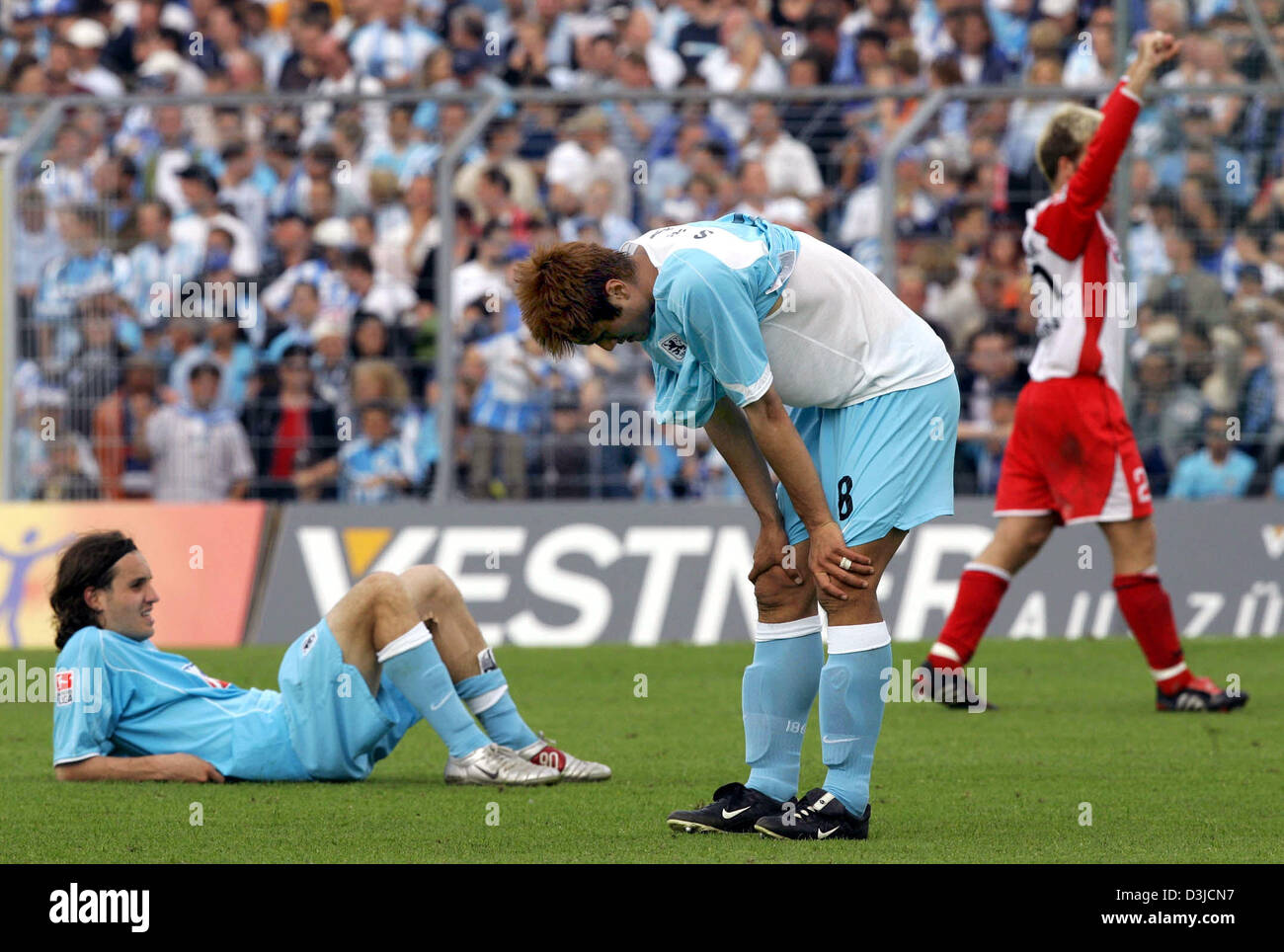 (dpa) - Players Remo Meyer (L) and Jiayi Shao (C) of soccer club TSV 1860 Munich look extremely depressed after their 3-4 defeat against LR Ahlen in the Second Bundesliga match at the Gruenwalder stadium in Munich, Germany, 22 May 2005. Munich failed to qualify for Germany's top soccer division. Stock Photo