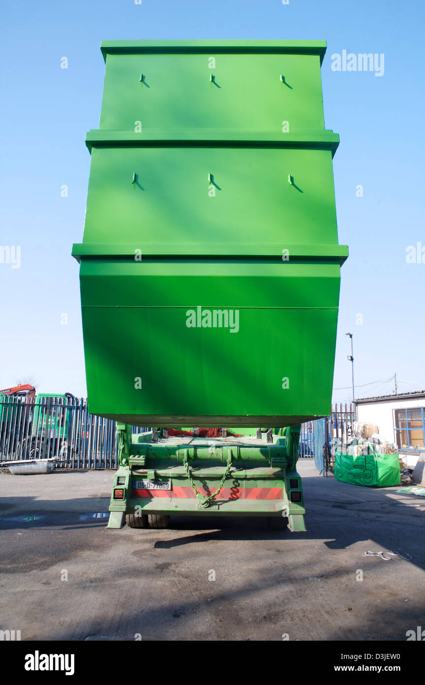 Refuse Collection truck lifting a skip onto its rear bay Stock Photo