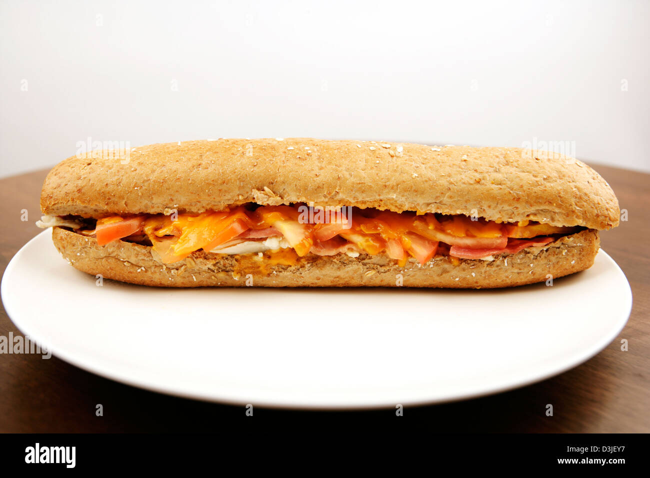 Cheese Ham Bacon Melt in a brown bread baguette Stock Photo