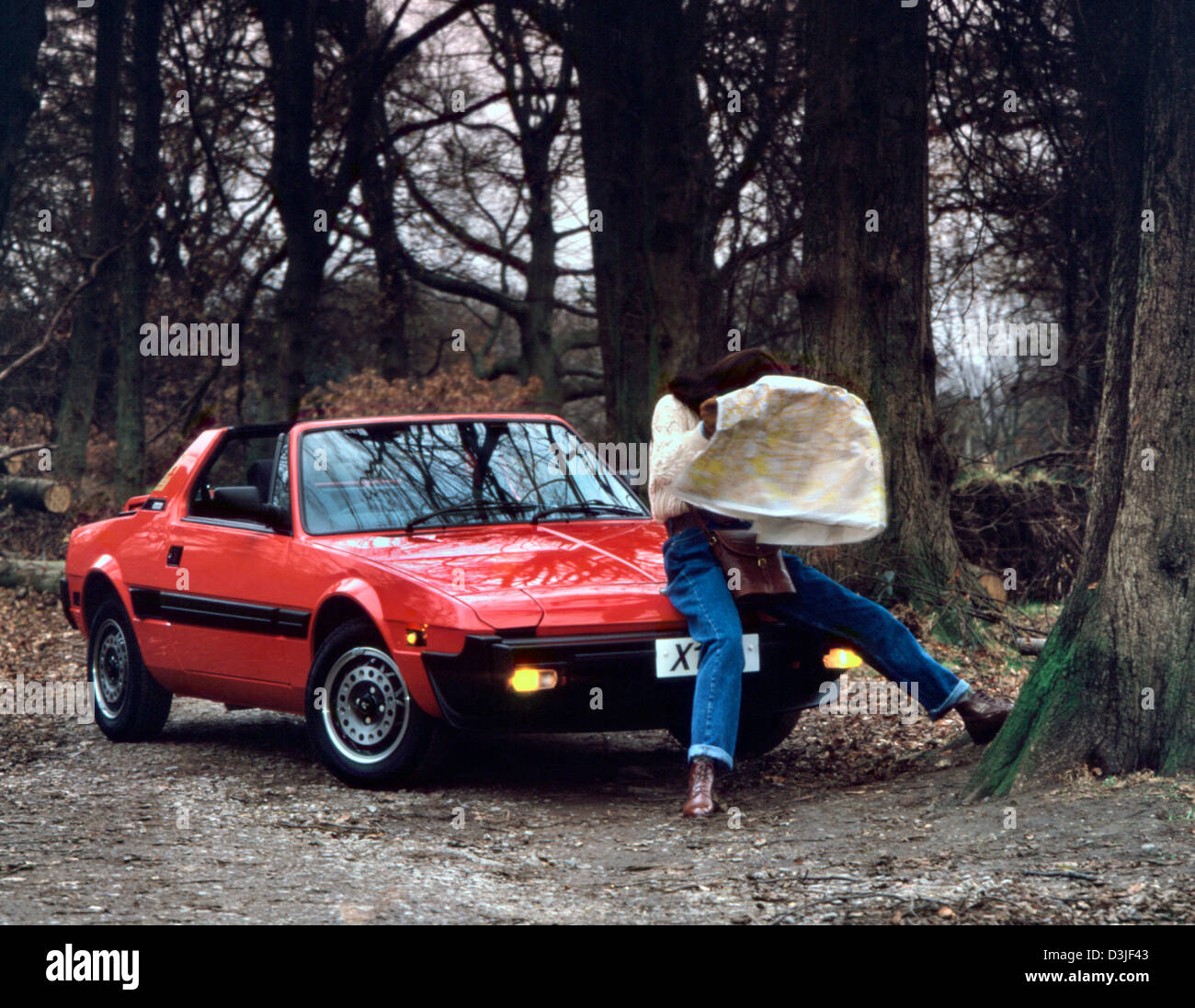 Young woman with her Fiat X1/9 sports car 1983 Stock Photo