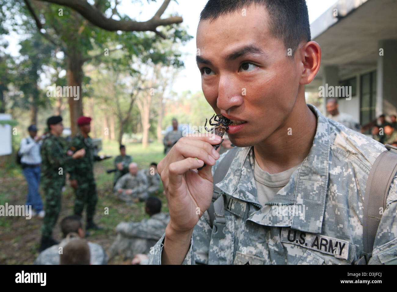 A US Marine eats a roasted cockroach during a jungle survival course February 16, 2013 in Ban Chan Krem, Thailand. The class teaches Marines basic jungle survival techniques as part of Exercise Cobra Gold 2013. Stock Photo