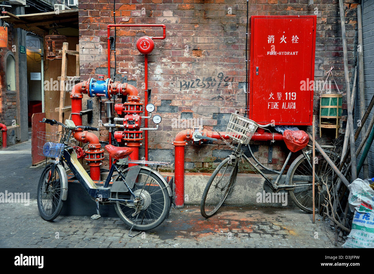 Bikes and red water pipes in an alley of Tianzifang, a renovated area in the French Concession near Taikang Lu, Shanghai - China Stock Photo