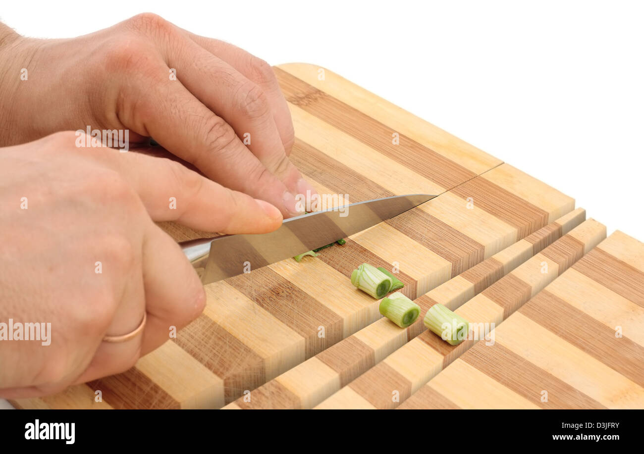 Conceptual image - hand with knife cuts onions and wood cutting board Stock Photo