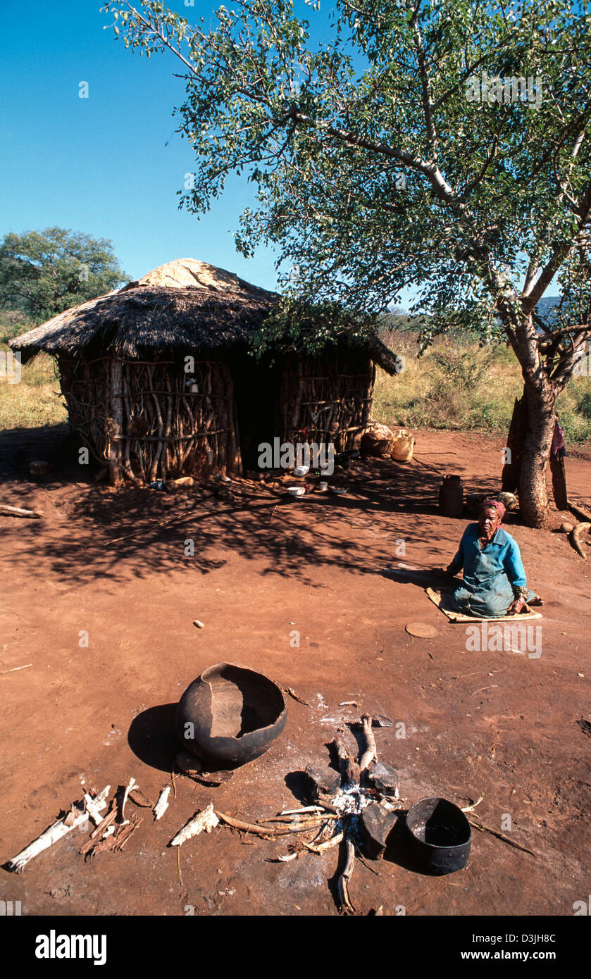 A destitute elderly woman sitting outside a rural homestead during a time of drought.. Siphofaneni, Eswatini (Swaziland) Stock Photo
