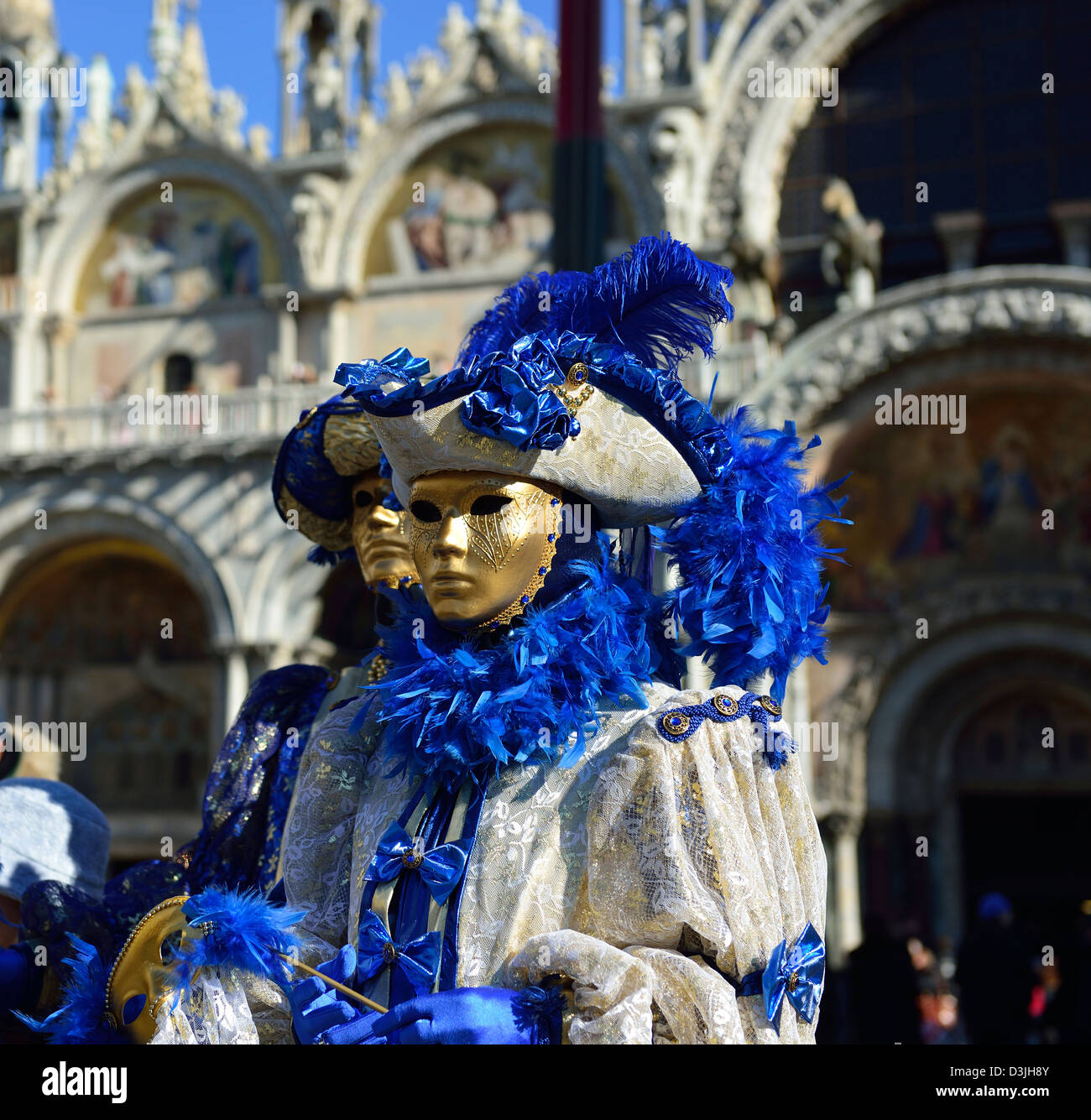 A couple of masks stand before the St.Mark basilica in Venice; Veneto, Italy. Stock Photo