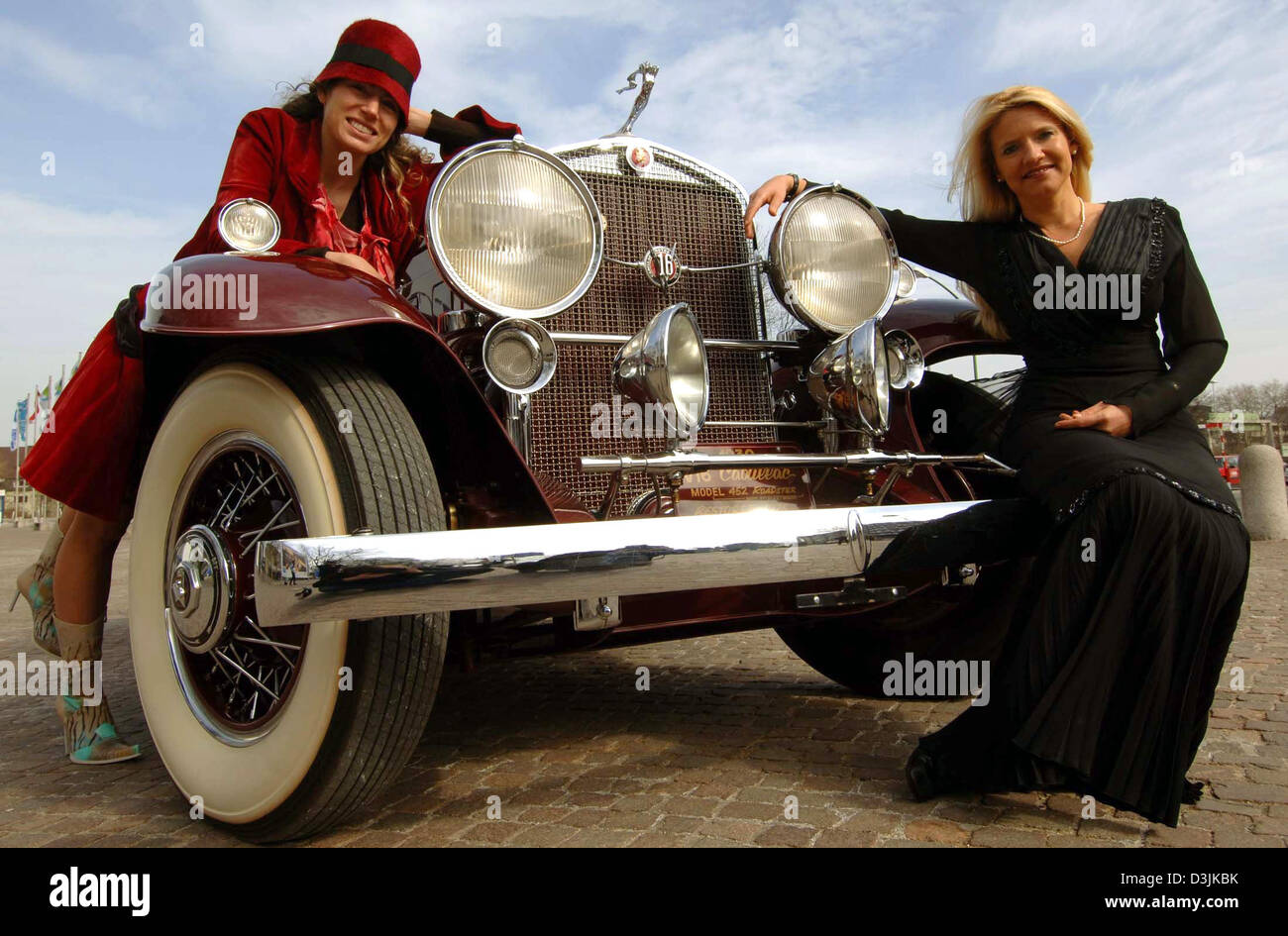 (dpa) - Two models, dressed in clothes of the 1930s, pose on a Cadillac Fleetwood vintage car from 1930 in Essen, Germany, 22 March 2005. The car was  once owned by the legendary Howard Hughes. The Cadillac is valued at an estimated 1,15 million euros. Vintage car fair 'Techno Classica 2005' runs from 07 April to 10 April 2005. More than 1,000 international exhibitors present more  Stock Photo