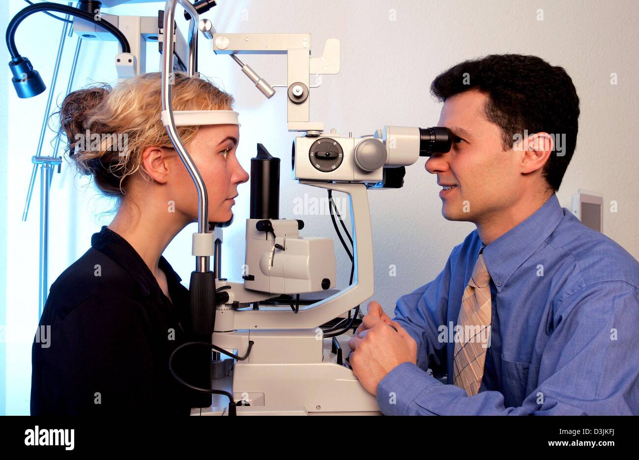 (dpa) - Eye surgeon, doctor med Suphi Taneri, examines the eyes of a patient with a slit lamp in preparation for LASIK eye surgery at the Hohenzollernklinik - Centre for refractive surgery in Muenster, Germany, 27 January 2005. LASIK stands for 'Laser-Assisted In Situ Keratomileusis' and refers to a surgical procedure on the eye with an excimer laser intended to reduce a person's d Stock Photo