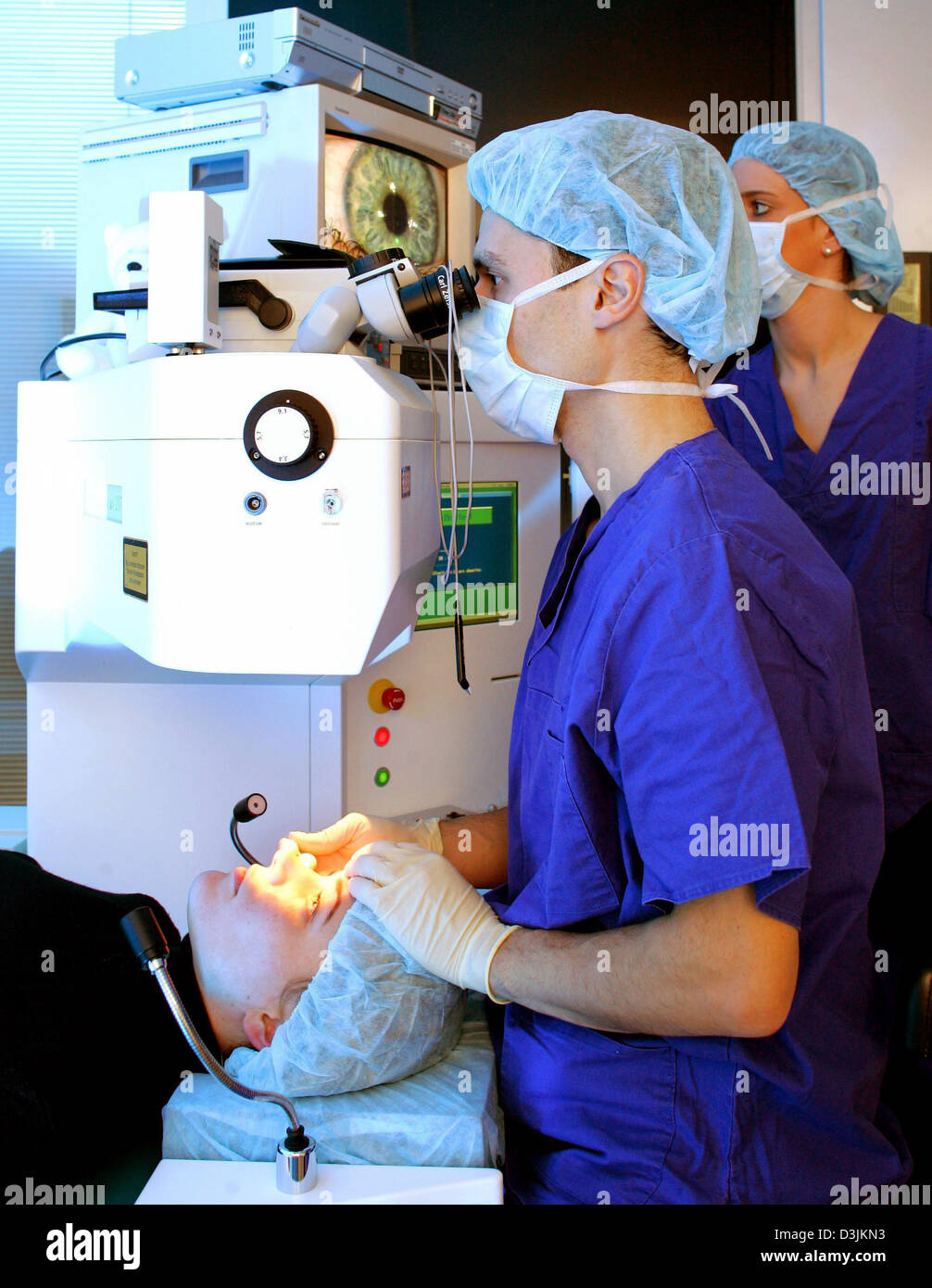 (dpa) - Two medical doctors stand in the operating theatre as they perform LASIK eye surgery on a patient at the Hohenzollernklinik -Centre for refractive surgery in Muenster, Germany, 27 January 2005. LASIK stands for 'Laser-Assisted In Situ Keratomileusis' and refers to a surgical procedure on the eye with an excimer laser intended to reduce a person's dependency on glasses or co Stock Photo